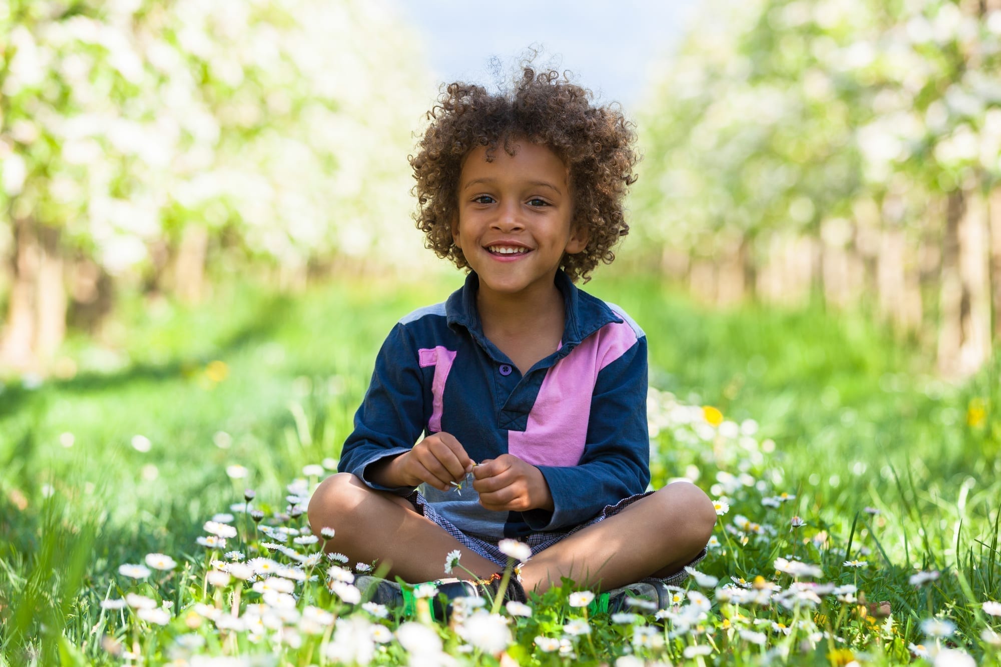 young african american boy sitting in grass
