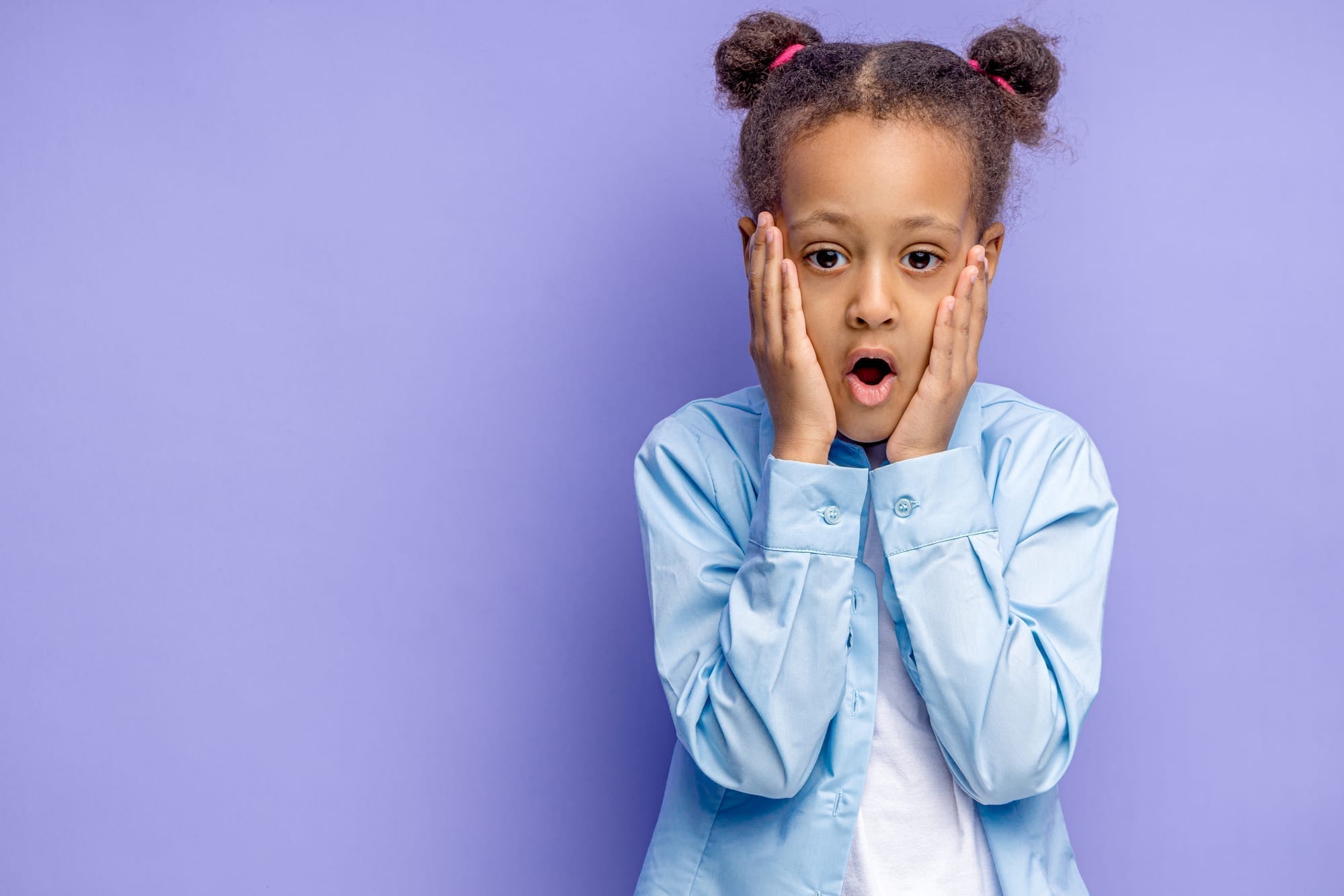 little girl with surprised or fearful face on purple background
