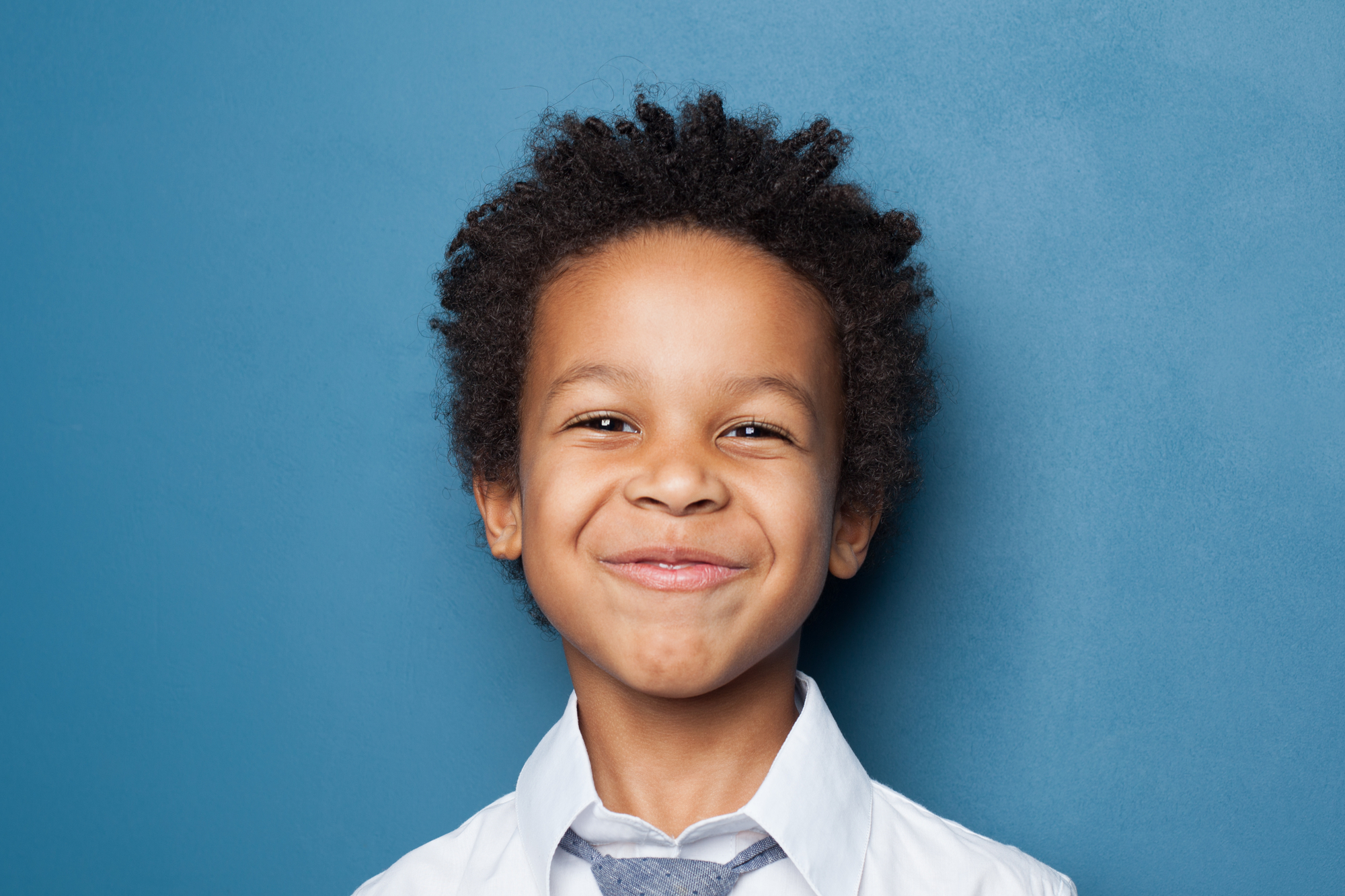portrait of african american boy on blue background