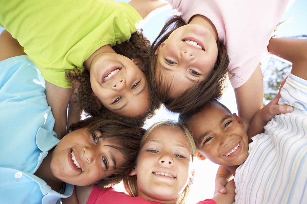 five children smiling in a circle for National Children's Dental Health Month
