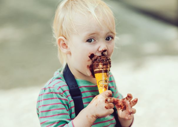 toddler eating a chocolate ice cream cone which might cause sensitive teeth