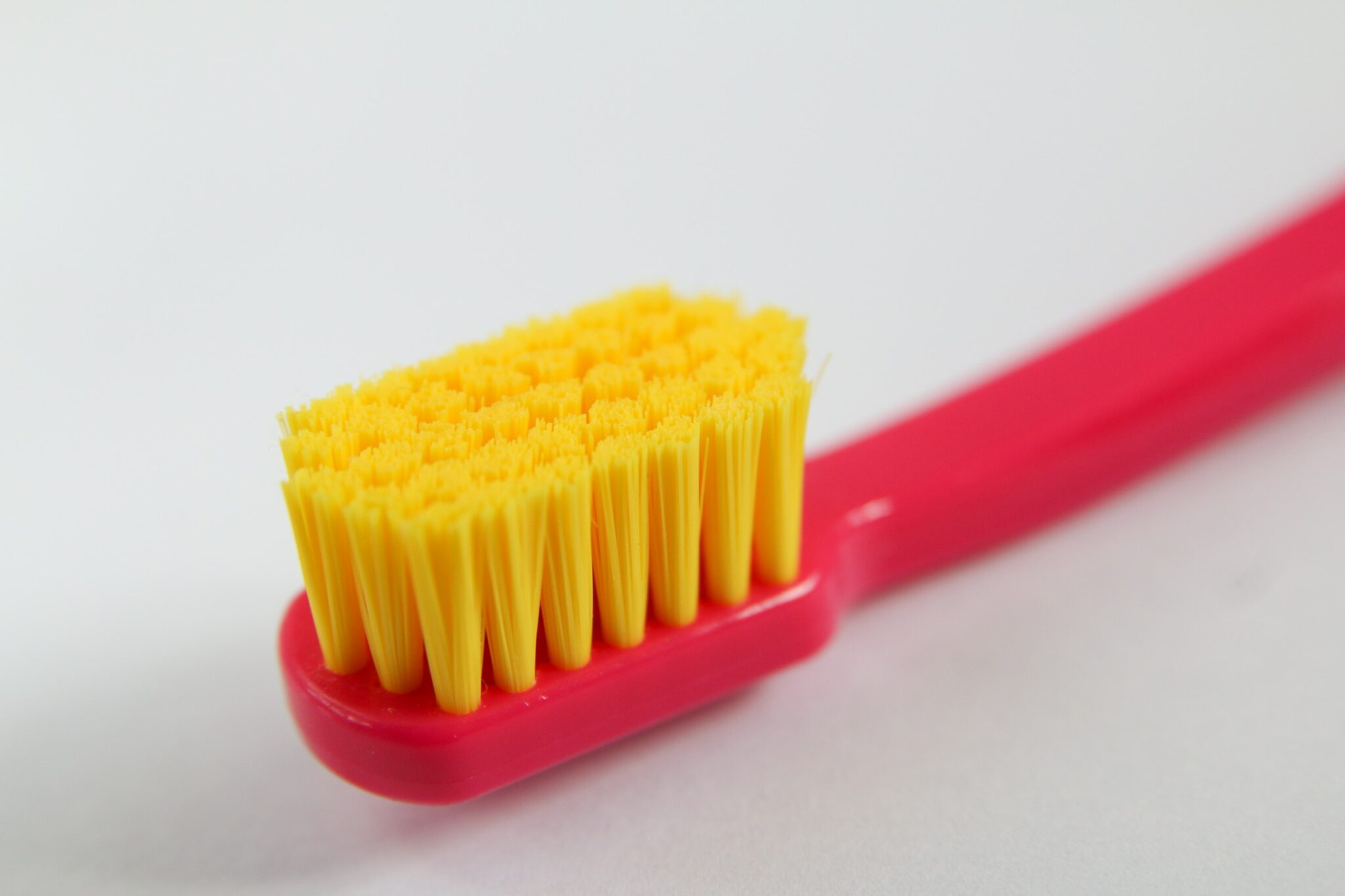 Red toothbrush with yellow bristles