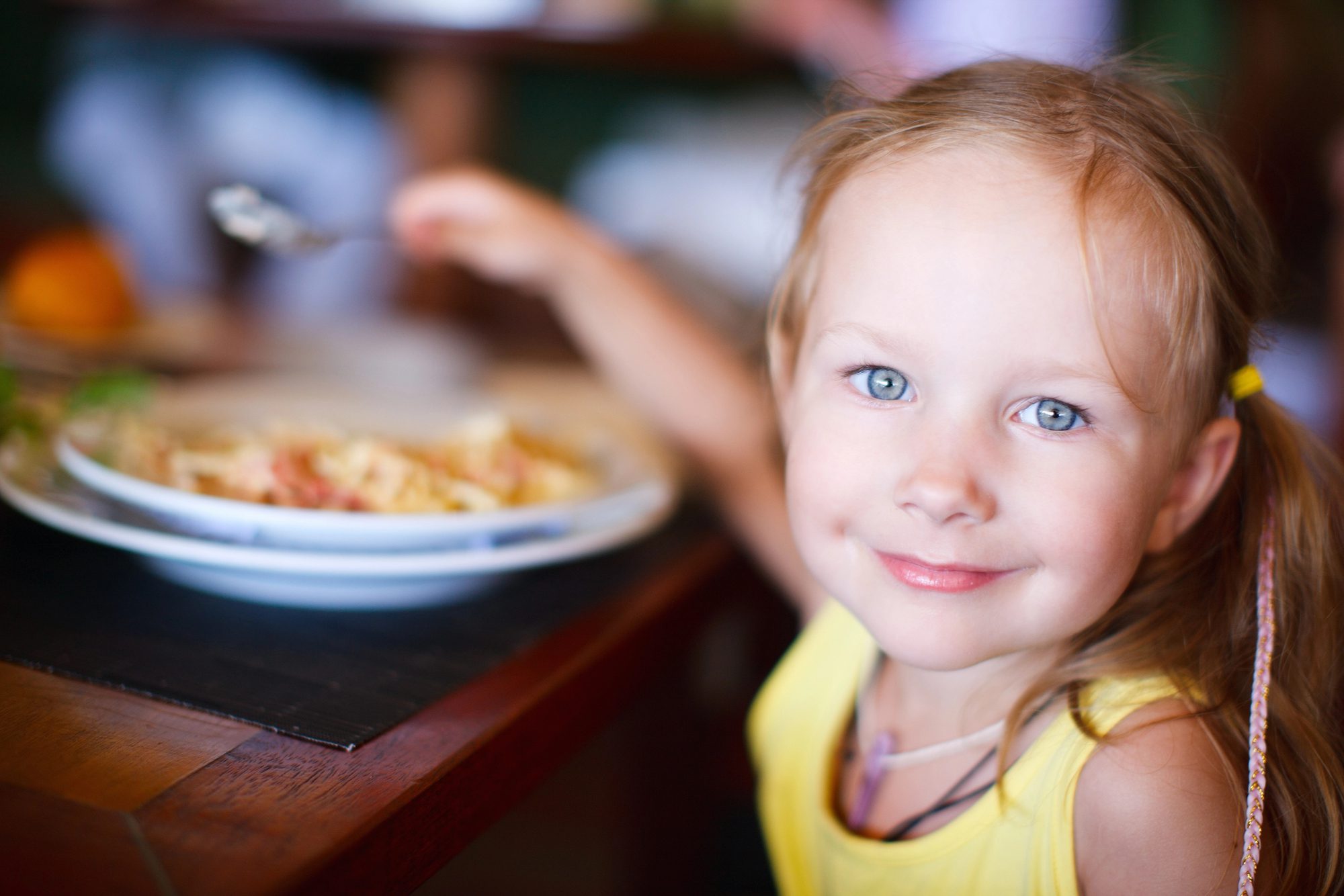 little girl eating at the table