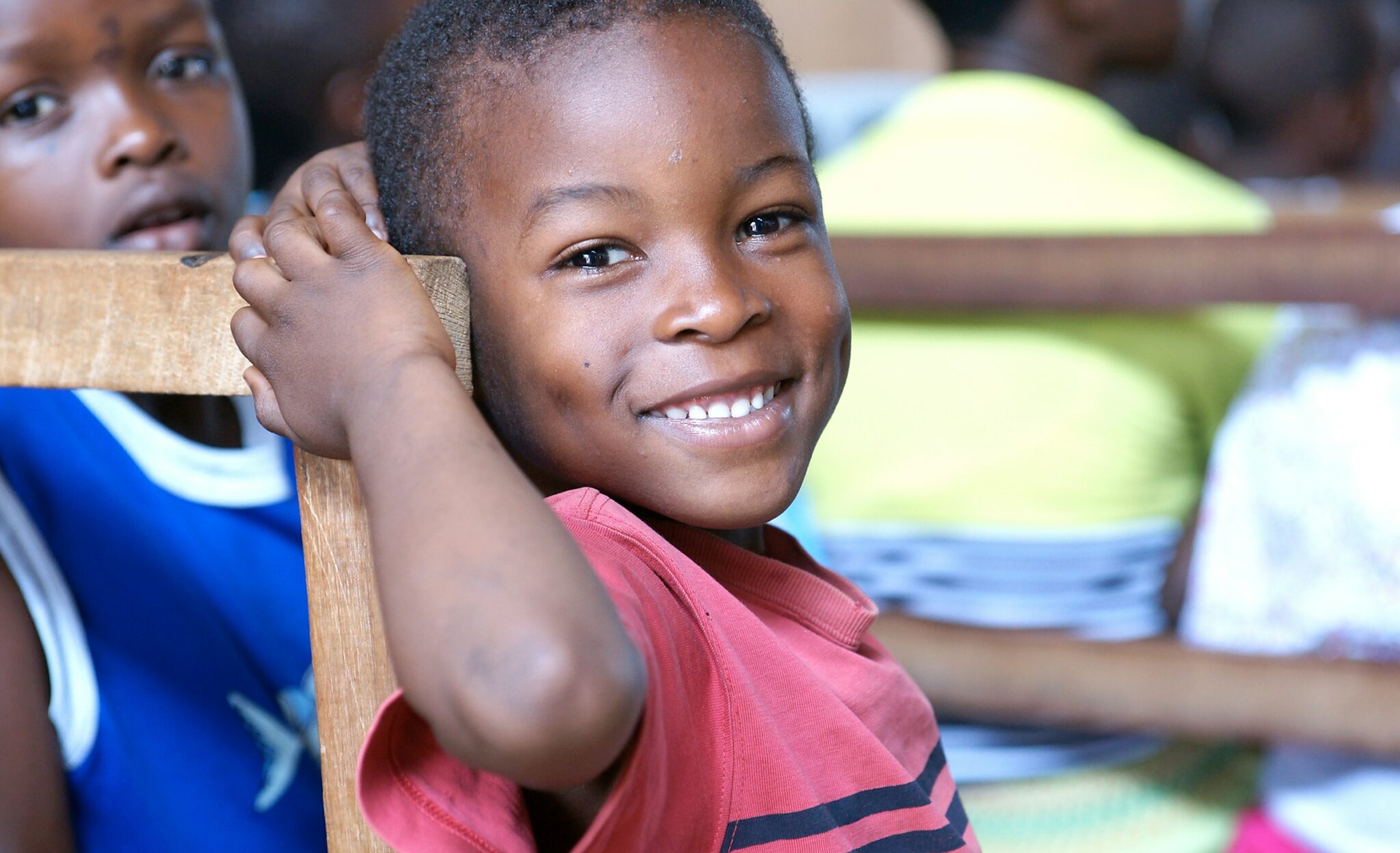 young african american boy smiling at camera in classroom
